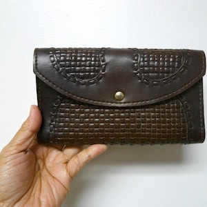Cartera de múltiples compartimentos en piel marrón labrada. Interior de gamuza. Fabricada en Brasil.