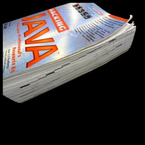 以下が含まれることがあります： 「Hacking Java: The Java Professional's Resource Kit」というタイトルの本が積み重なっています。オレンジと青色の表紙で、本のタイトルは大きなオレンジ色の文字で表示されています。本のページが見えており、新品または使用感が少ないことを示唆しています。