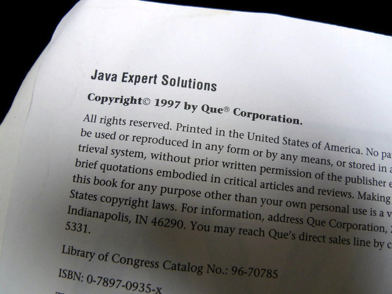 以下が含まれることがあります： 「Java Expert Solutions」というタイトルと、Que&reg; Corporationによる1997年の著作権情報が記載された本のページのクローズアップ。テキストは白地に黒で印刷されています。米国議会図書館のカタログ番号とISBNも表示されています。