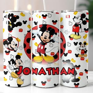 May include: Three white stainless steel tumblers with a Mickey Mouse theme. The tumblers feature a variety of Mickey Mouse characters and designs, including Mickey Mouse, Minnie Mouse, and Goofy. The tumblers are personalized with the name "JONATHAN".