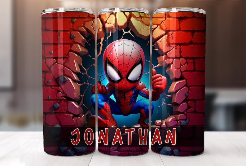 May include: A red and blue cartoon Spider-Man character breaks through a brick wall. The tumbler has a personalized name, "JONATHAN", printed on the bottom.