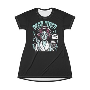Könnte beinhalten: Schwarzes Kleid mit einer Illustration einer Zombie-Frau. Die Frau hat Lockenwickler, raucht eine Zigarette und hält eine Kaffeetasse. Der Text enthält "DEAD TIRED" und "DON'T WAKE ME". Auf der Kaffeetasse steht "BRAIN".