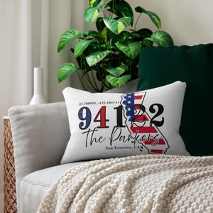 May include: White rectangular cushion with a design featuring the California state outline in red and white, with a blue and white American flag design. The text includes the zip code 94122, the words "The Parkers", and "San Fransisco, CA".