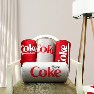 a coca - cola chair with three soft drinks on it