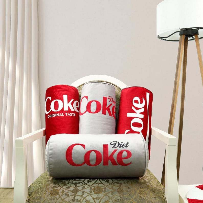 a coca - cola chair with three soft drinks on it