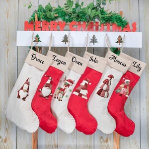 May include: Six Christmas stockings hanging from a white wooden rack with the text MERRY CHRISTMAS. The stockings feature personalized names Grace, Logan, Owen, Isla, Marcus, and Lily, with festive patterns including gnomes, reindeer, and trees.