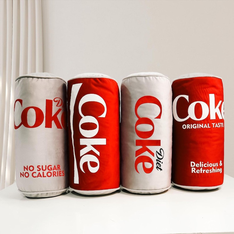 a row of coke cans sitting on top of a white counter