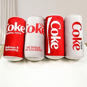 a row of coke cans sitting on top of a counter