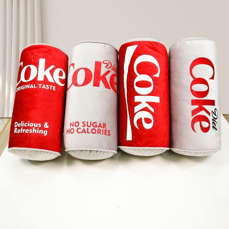 a row of coke cans sitting on top of a counter
