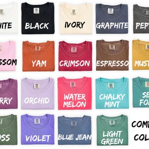 a collection of 16 t-shirts, each with a different color and design, arranged in a grid pattern.