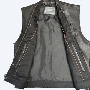 May include: Black leather vest with a zipper closure and snap buttons. The vest has a brown lining and a label that reads "Pro Rider Leathers U.S.A."