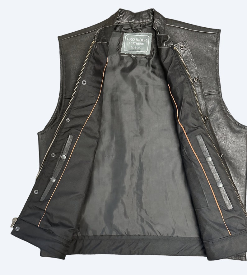 May include: Black leather vest with a zipper closure and snap buttons. The vest has a brown lining and a label that reads "Pro Rider Leathers U.S.A."