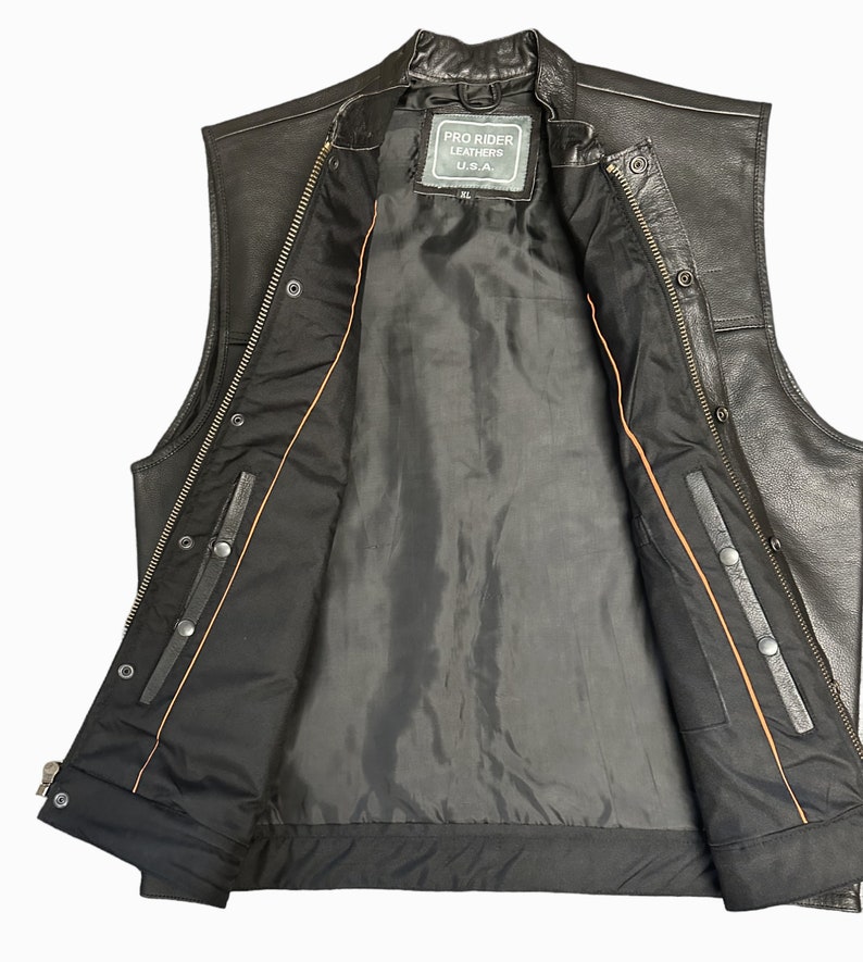May include: Black leather vest with a zipper closure and snap buttons. The vest has a brown lining and a label that reads "Pro Rider Leathers U.S.A."