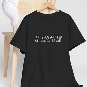 Könnte beinhalten: Schwarzes T-Shirt mit weißem Text, der "I BITE" in einer fetten, umrandeten Schrift sagt.