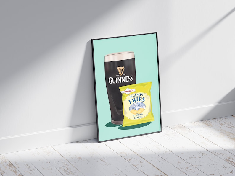 May include: A framed print featuring a pint of Guinness and a packet of Scampi Fries. The Guinness glass is black with the white harp logo. The Scampi Fries packet is yellow with blue text, including "Scampi Fries" and "Scampi & Lemon".