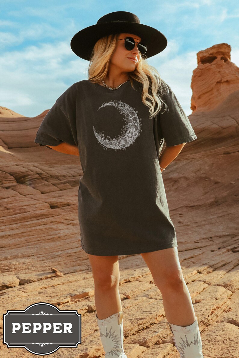Black and white floral crescent moon design on a minimalist boho t shirt, showcasing delicate nature inspired linework that forms an elegant lunar shape perfect for astrology lovers and those seeking celestial style.