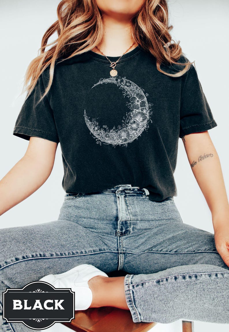 Black and white floral crescent moon design on a minimalist boho t shirt, showcasing delicate nature inspired linework that forms an elegant lunar shape perfect for astrology lovers and those seeking celestial style.