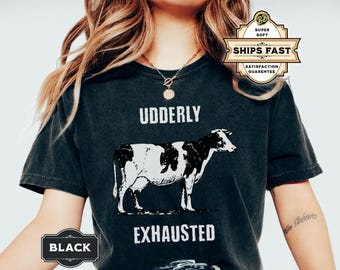 May include: Black t-shirt with a white cow illustration and the text "Udderly Exhausted".