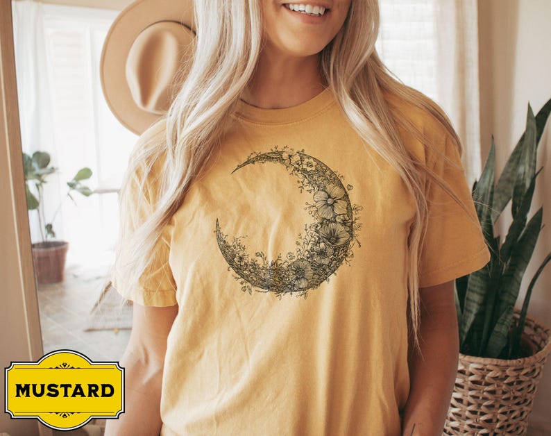 Black and white floral crescent moon design on a minimalist boho t shirt, showcasing delicate nature inspired linework that forms an elegant lunar shape perfect for astrology lovers and those seeking celestial style.