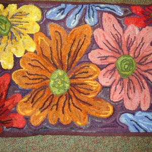 May include: A colorful rug with a floral design. The rug features a variety of flowers in shades of yellow, orange, pink, blue, and red. The flowers are all hand-stitched and have a unique, textured look.