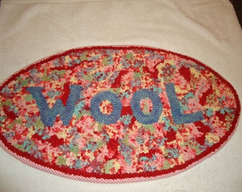 Oval rug hooking hooked pattern with "WOOL" lettering on primitive linen