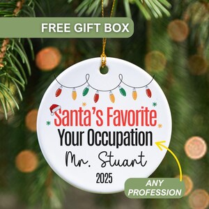 May include: A white ceramic Christmas ornament with the text "Santa's Favorite Your Occupation Mr. Stuart 2025" in red and black. The ornament has a string of colorful Christmas lights and a Santa hat graphic. The words "Any Profession" are also included.