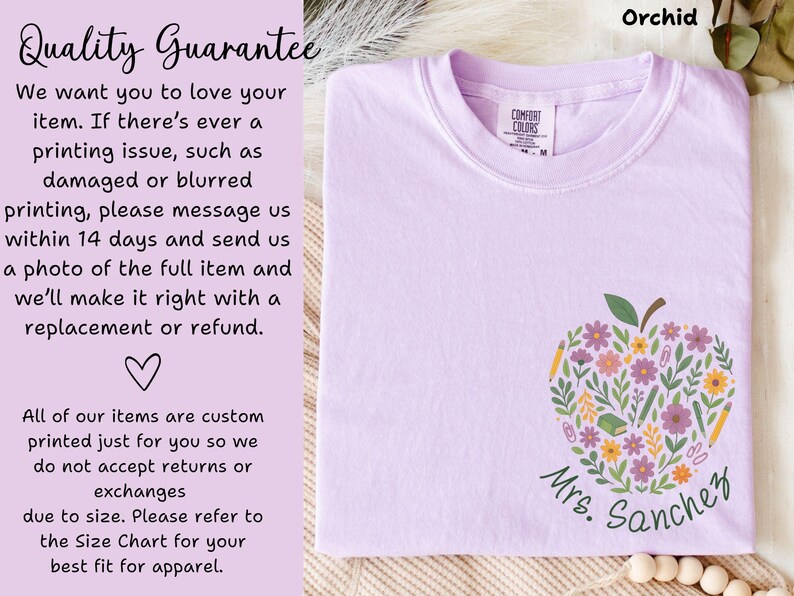 May include: Orchid-colored t-shirt featuring a floral apple design with pencils and flowers, and the name "Mrs. Sanchez" in green script. The shirt has a Comfort Colors tag and text that says "Quality Guarantee".