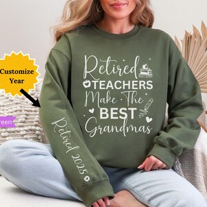 Pode incluir: Uma camisa de frio verde com o texto "Retired Teachers Make The Best Grandmas" e "Retired 2023" na manga. A camisa de frio est&aacute; sendo usada por uma pessoa.