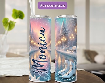 May include: A stainless steel tumbler with a winter ice skating scene. The design features a skating rink, trees, and a bench, with the name "Monica" in cursive. The tumbler has a straw and a lid, with the word "Personalize" at the top.