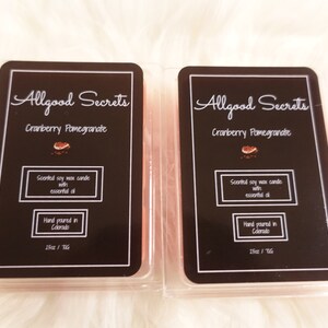 May include: Two cranberry pomegranate scented soy wax candles with essential oil. Each candle is hand-poured in Colorado and packaged in a clear plastic container. The label reads "Allgood Secrets".