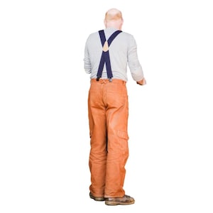May include: A person wearing a gray long-sleeve shirt, orange work pants with cargo pockets, and blue suspenders. The person is wearing brown work boots. The background is white.
