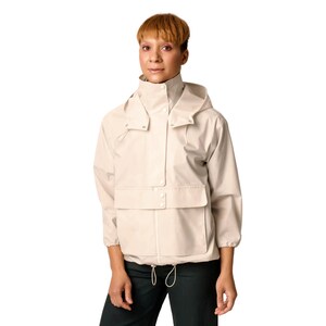 May include: A beige hooded jacket with a zipper closure and a large front pocket. The jacket has a drawstring at the waist.