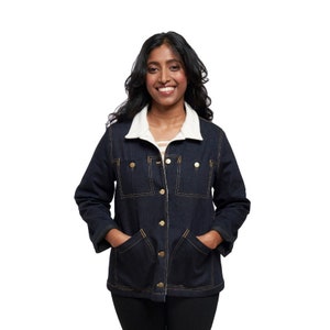 May include: A dark blue denim jacket with a white sherpa lining and gold buttons. The jacket has two large pockets on the front and a button-up closure.