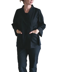 May include: A black wrap jacket with long sleeves and a tie belt. The jacket has pockets on both sides.