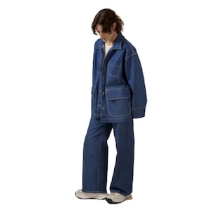 May include: A denim jacket and matching wide-leg pants in a medium blue wash. The jacket has large front pockets and button closures. The pants have a relaxed fit. The outfit is worn with a white t-shirt and sneakers.