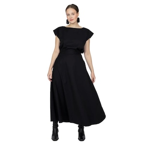 May include: A black, knee-length skirt with a wide waistband and a flowing silhouette. The skirt is made of a lightweight fabric and has a casual, relaxed fit.