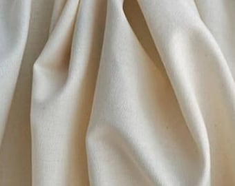 May include: A close-up of a smooth, off-white fabric with a soft, natural texture. The fabric is folded and draped, showcasing its drape and flow.