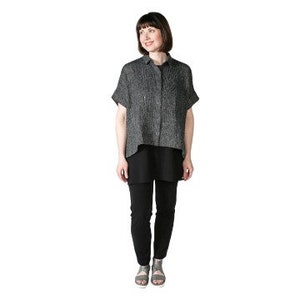 May include: A gray linen shirt with short sleeves and a button-down front. The shirt has a relaxed fit and a slightly longer back hem.