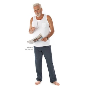 May include: A man wearing a white tank top with a pocket and blue patterned pajama pants is holding a newspaper and glasses. The text on the newspaper reads "4134 BEN 4132 MARTIN".