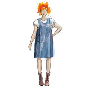 May include: A woman wearing a denim overall dress with a white t-shirt underneath. She has red hair and is wearing brown boots.