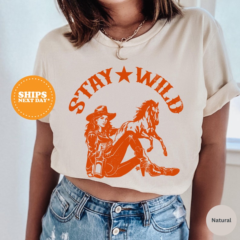 a woman wearing a crop top that says stay wild