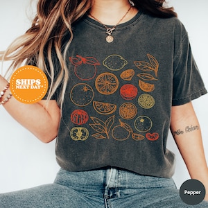 a woman wearing a t - shirt with fruit on it