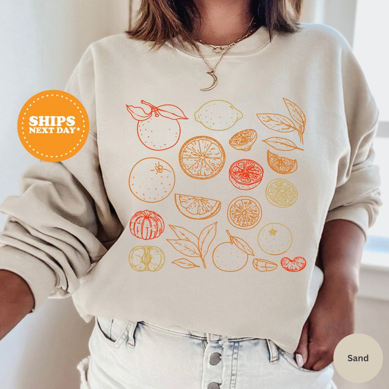 a woman wearing a sweatshirt with oranges on it