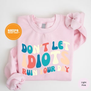 a pink shirt that says don't let idiots run your day