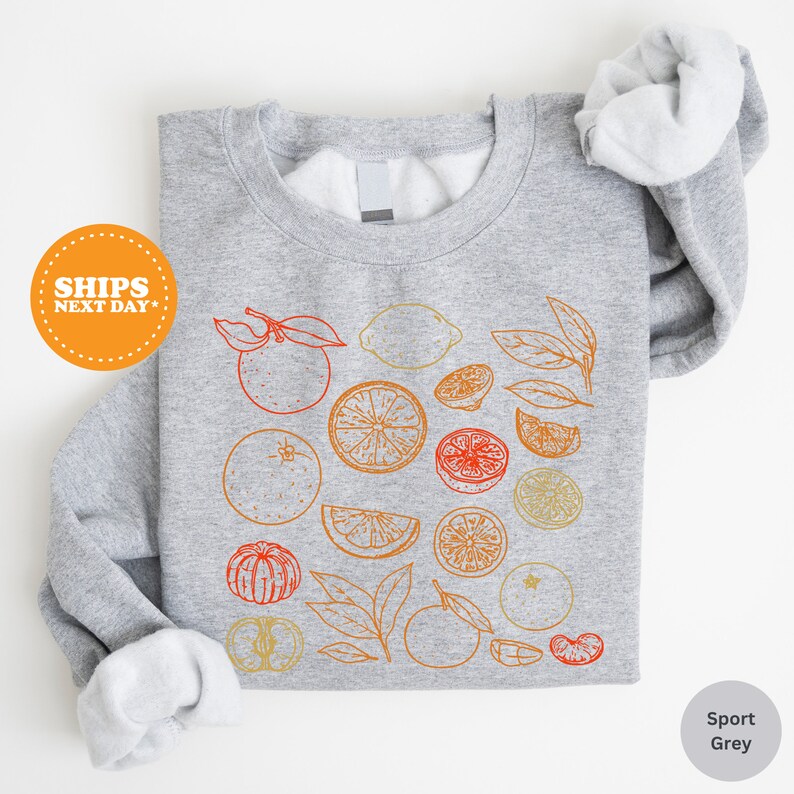 a gray shirt with oranges and lemons on it