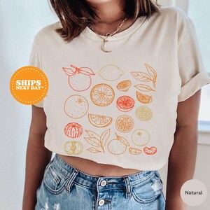 a woman wearing a crop top with fruit on it