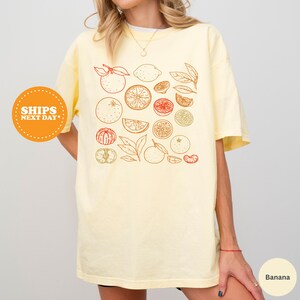 a woman wearing a t - shirt with fruit on it
