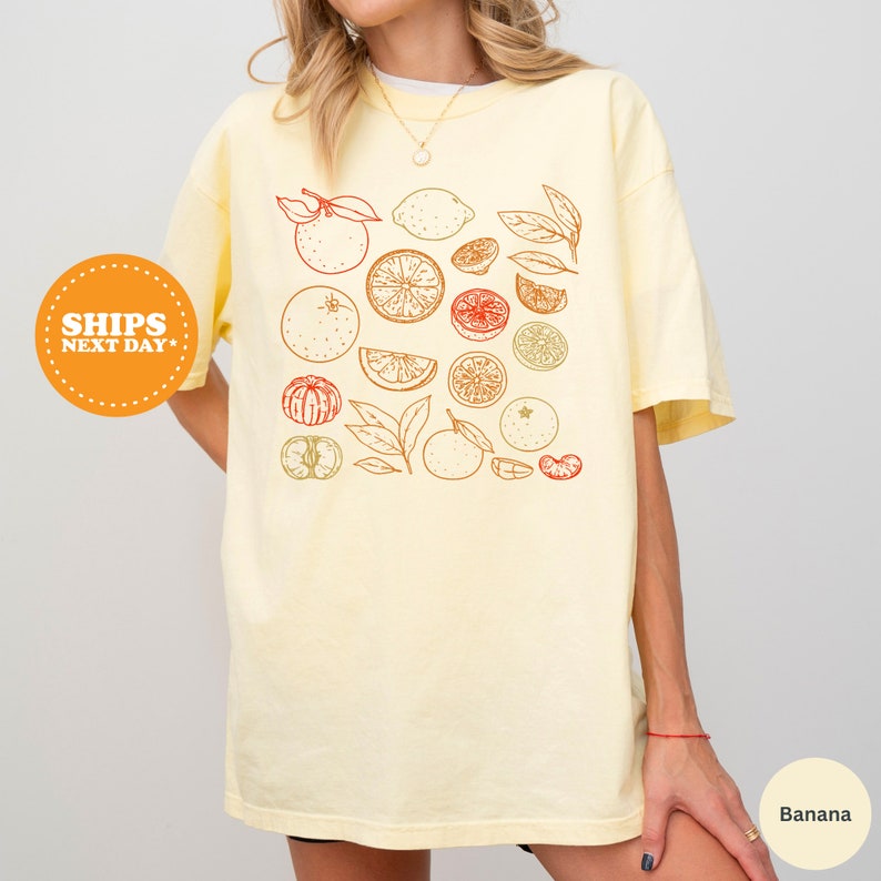 a woman wearing a t - shirt with fruit on it