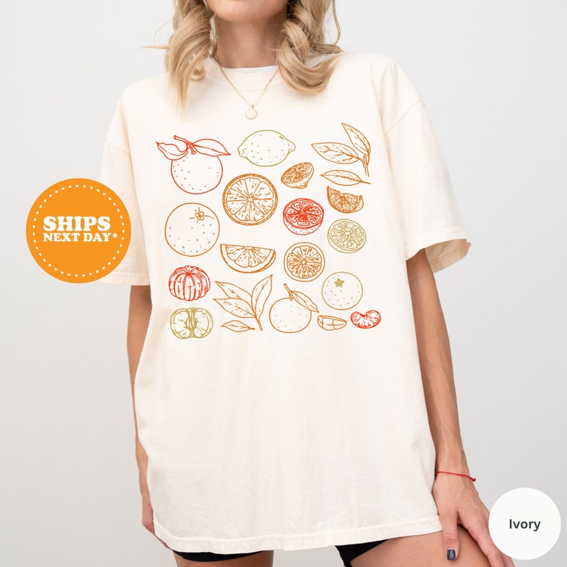 a woman wearing a white t - shirt with fruit on it