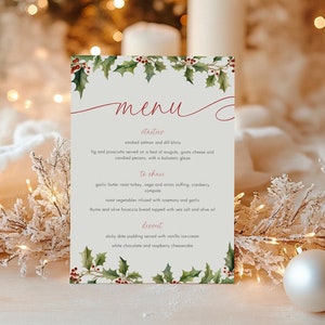 May include: A Christmas menu card with a watercolor illustration of holly leaves and berries. The menu includes appetizers, sides, and desserts. The text reads "Menu", "Appetizers", "Smoked salmon and dill blinis", "Fig and prosciutto served on a bed of arugula, goat cheese and candied pecans, with a balsamic glaze", "To share", "Garlic butter roast turkey, sage and onion stuffing, cranberry sauce", "Roast vegetables infused with rosemary and garlic", "Thyme and olive focaccia bread topped with sea salt and olive oil", "Dessert", "Sticky date pudding served with vanilla ice cream", "White chocolate and raspberry cheesecake"